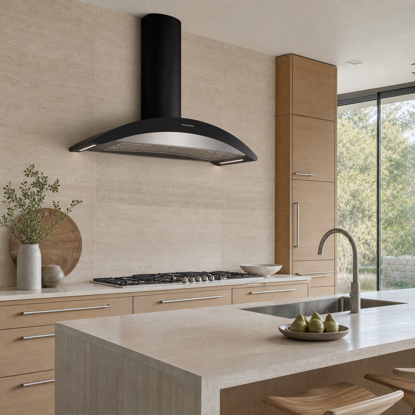 A modern kitchen scene featuring a black range hood mounted above a gas cooktop, with light wood cabinetry, a stone countertop,