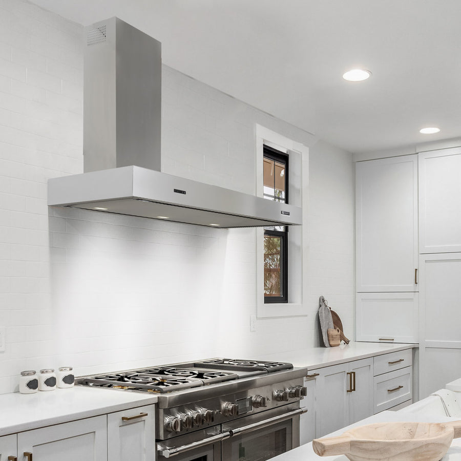Arezzo wall mounted cooker hood with left hand chimney in stainless steel. Situated above a range cooker in a white shaker style kitchen